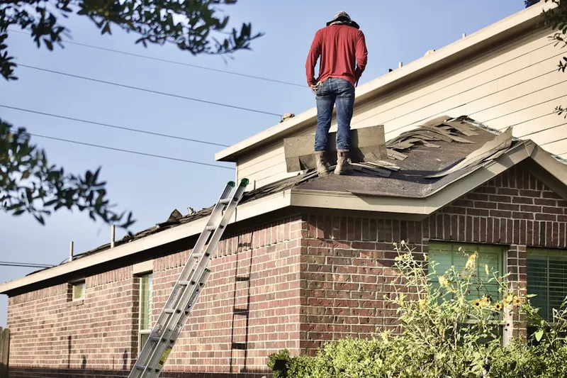 Professional roofer working on a residential roof in Hollingsworth